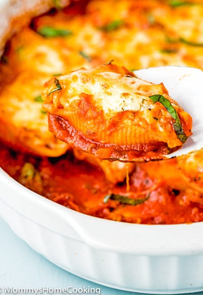 Eggless Ricotta Stuffed Shells in a white casserole in a serving spoon