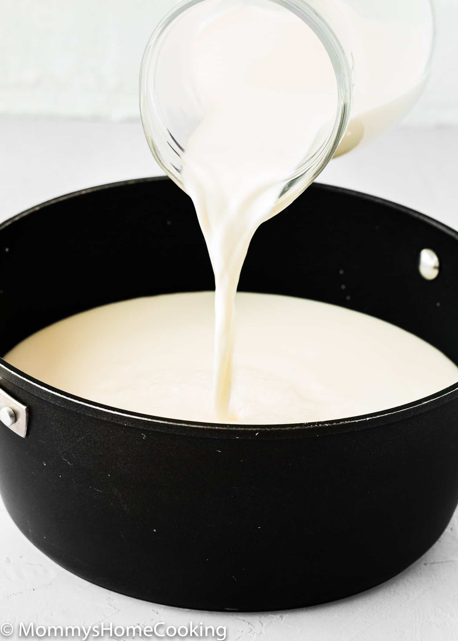 milk being poured into a pot. 