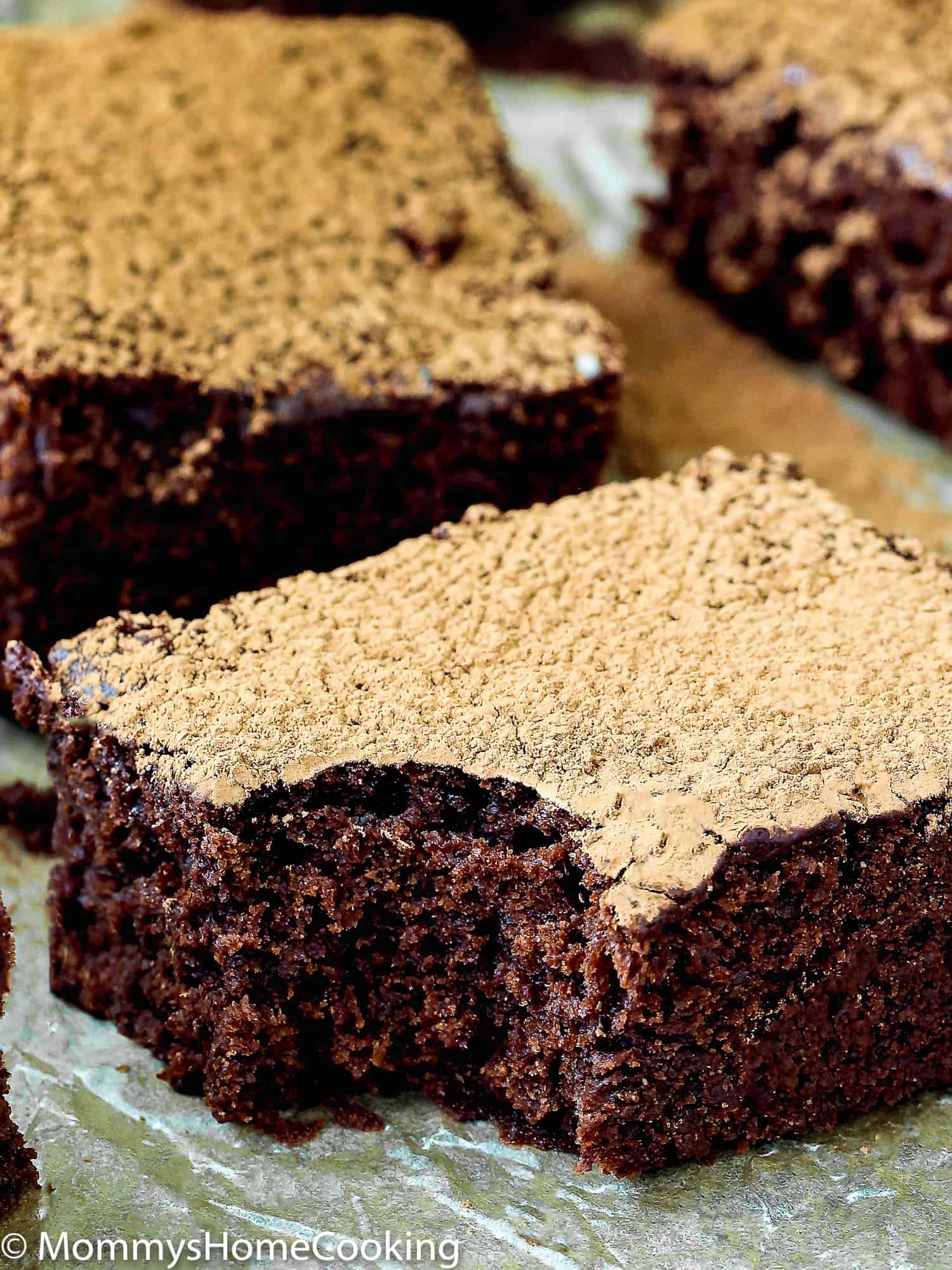 a bitten egg-free brownie with cocoa powder on top.