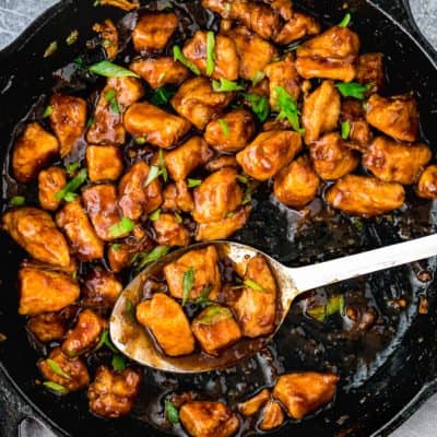 Easy Sticky Bourbon Chicken in a skillet with a serving spoon