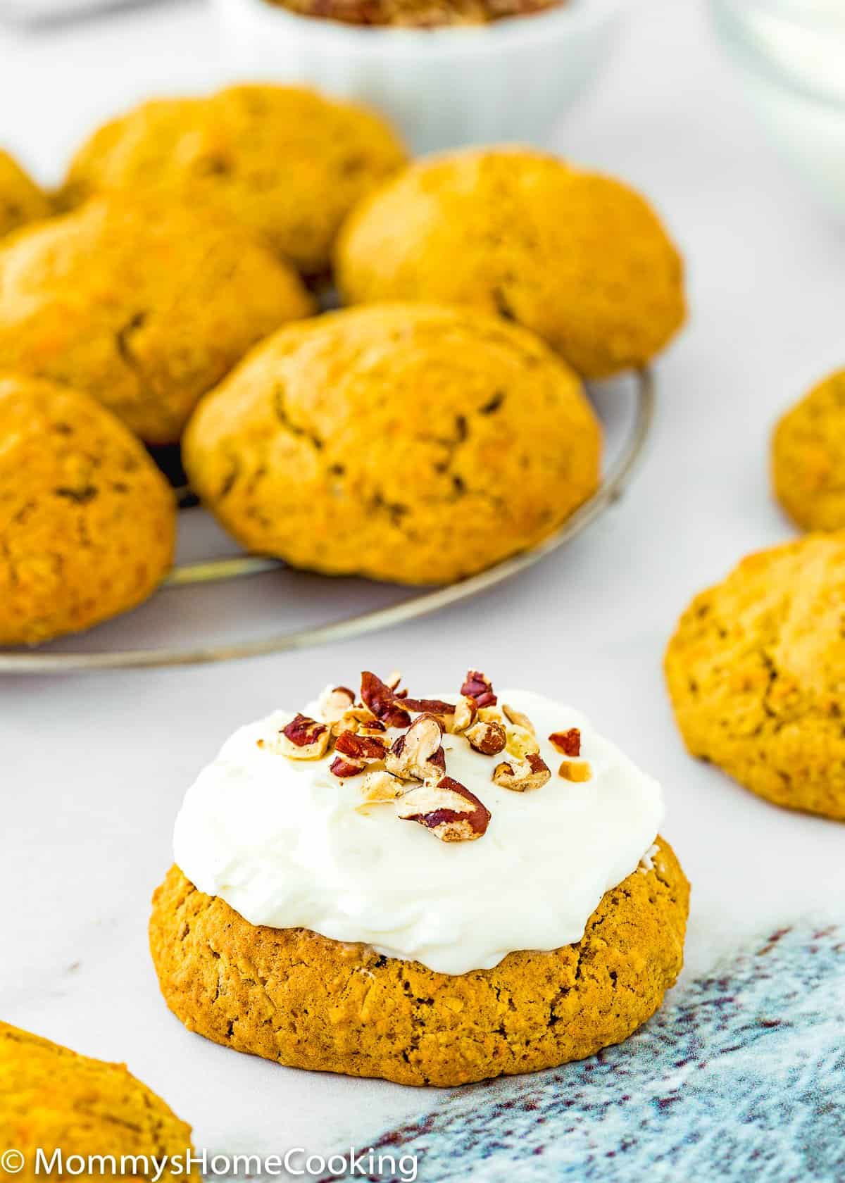 Eggless Carrot Cake Cookie with cream cheese frosting and chopped pecan on top.