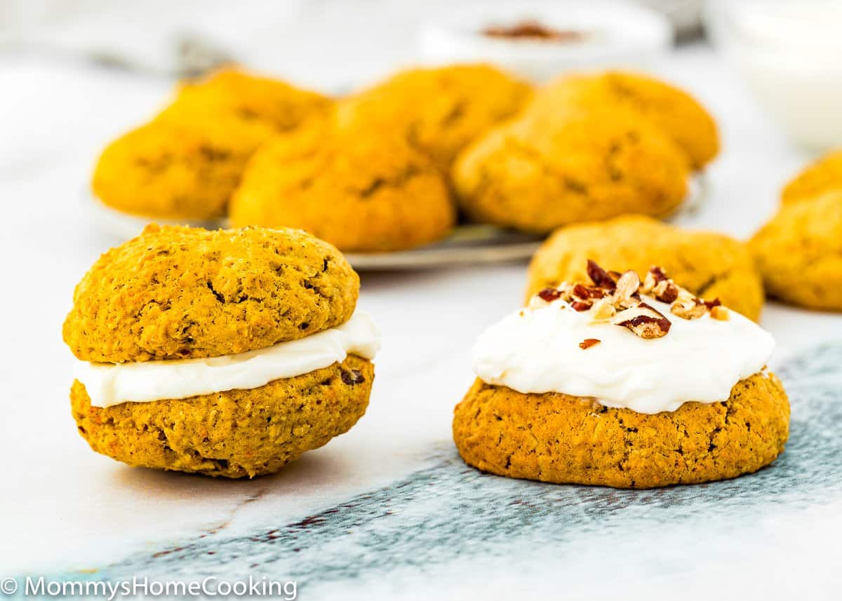 one Eggless Carrot Cake Cookie sandwich and one Eggless Carrot Cake Cookie with cream cheese frosting