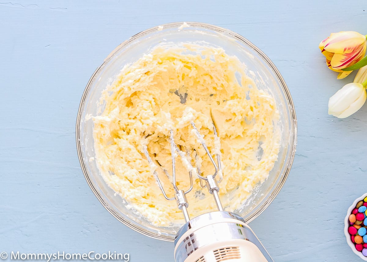a hand mixer beating butter and sugar in a bowl