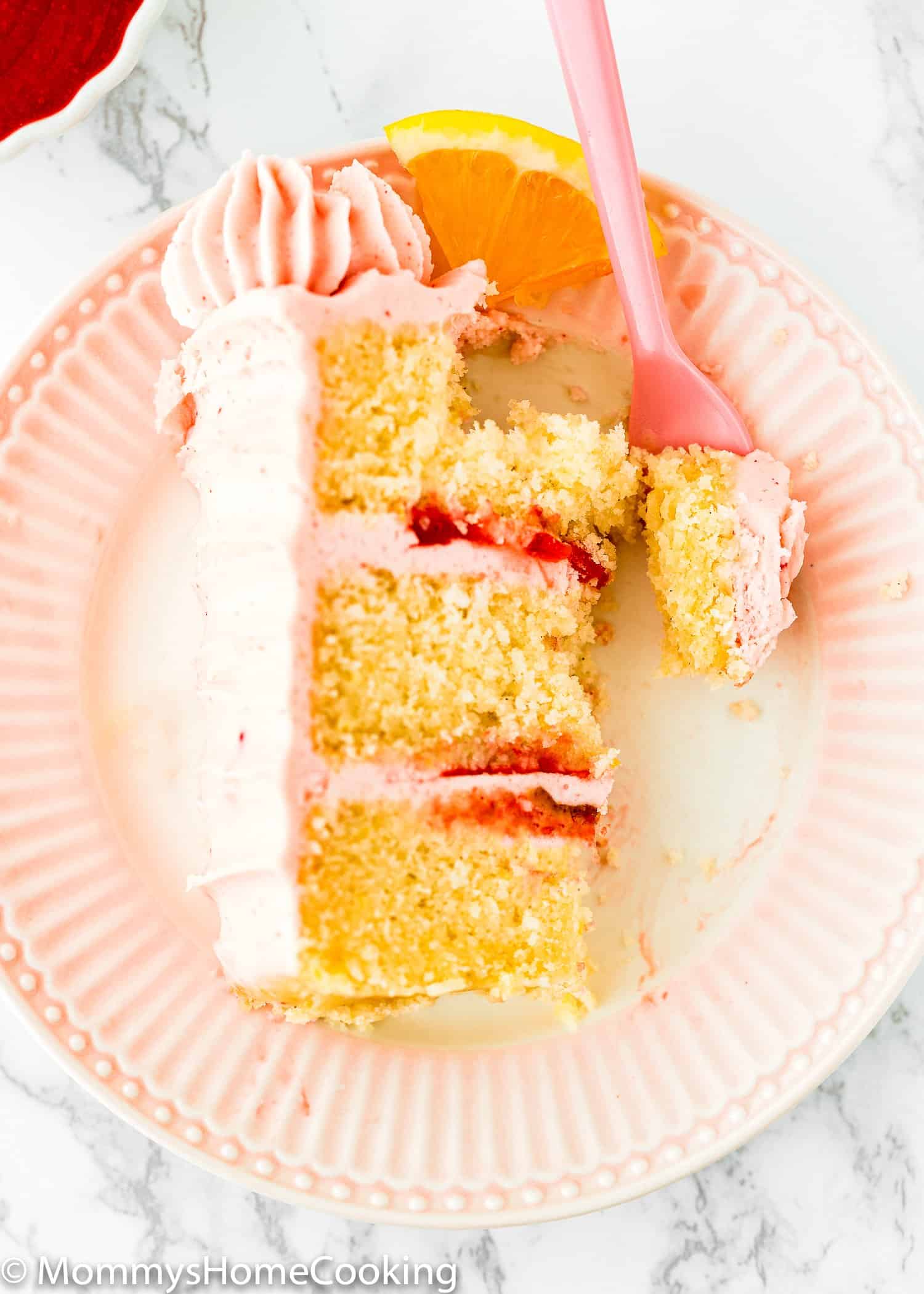overhead view of a slice of Eggless Strawberry Lemonade Cake with a fork.