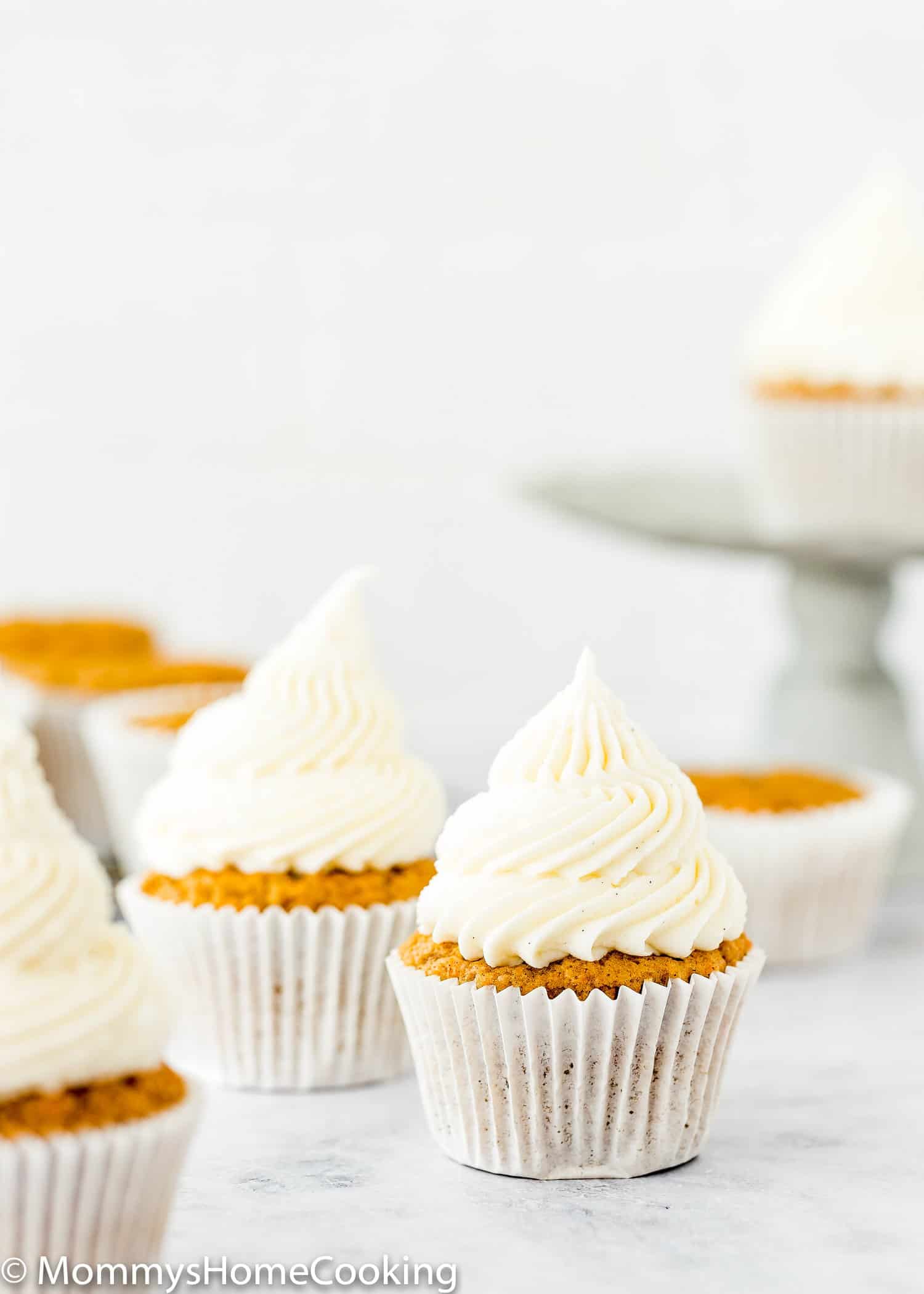 Eggless carrots cupcakes frosted with cream cheese frosting that isn't runny.