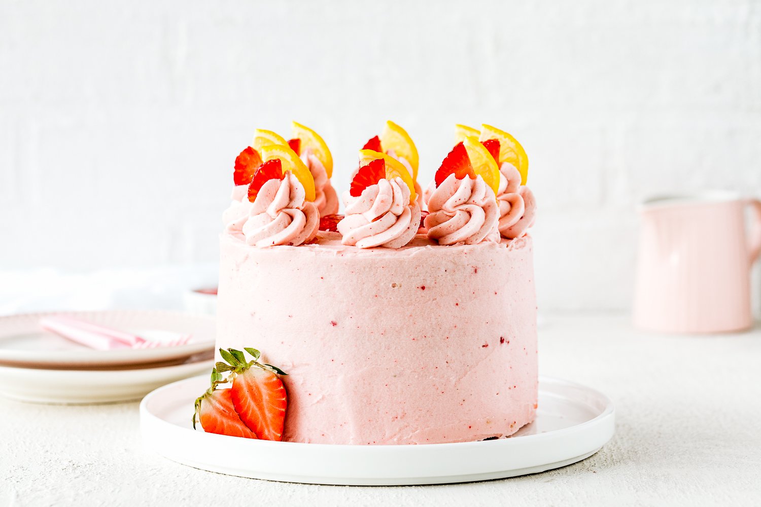 whole Eggless Strawberry Lemonade Cake over a serving plate.