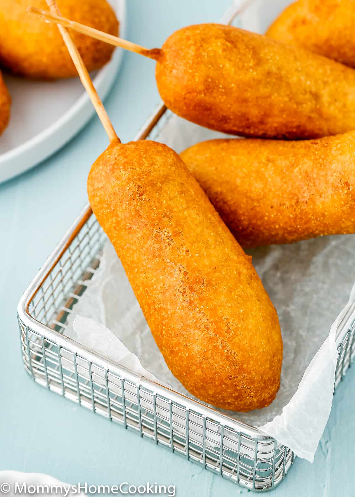 eggless corndogs over a blue table.