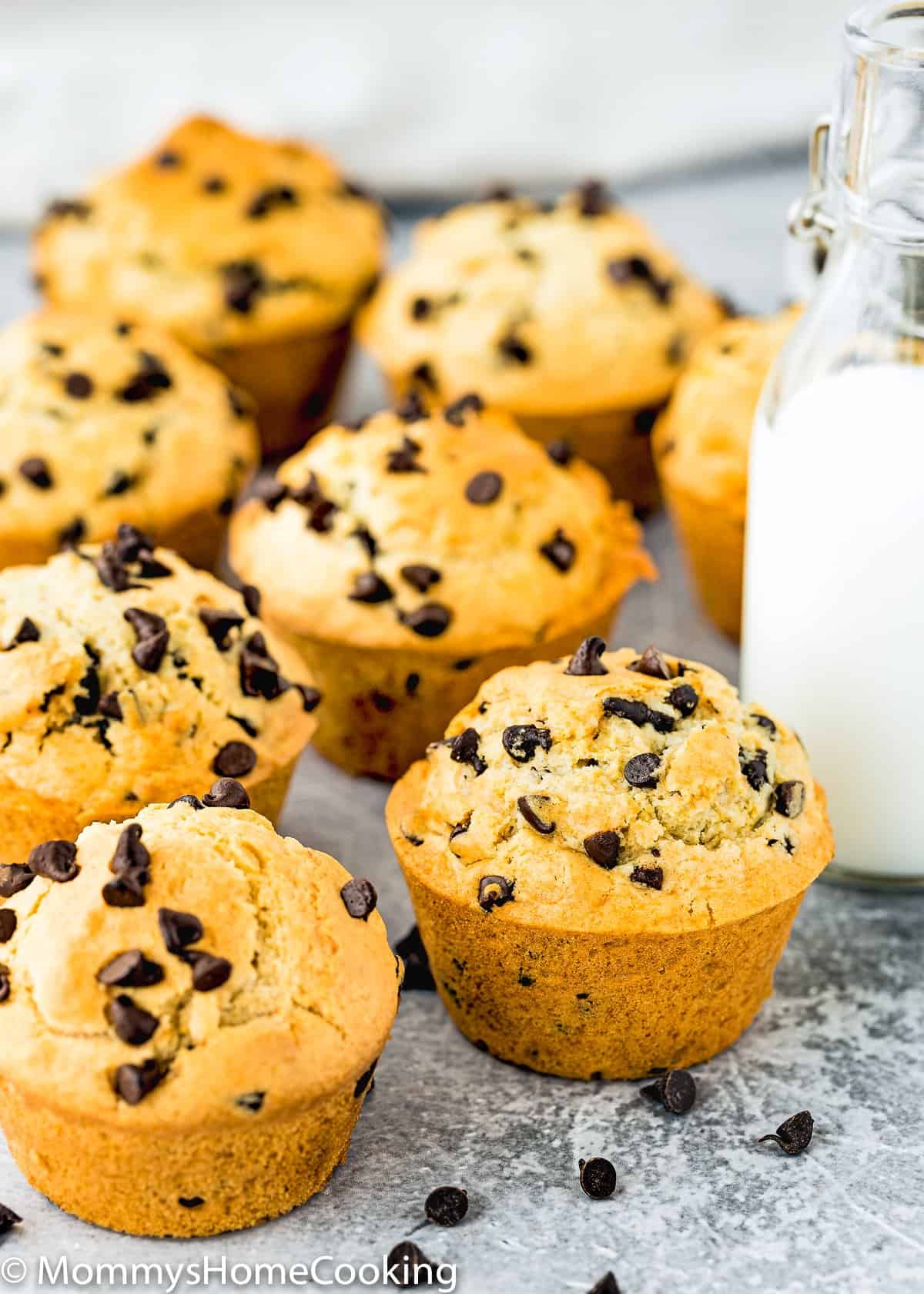 Eggless Bakery-Style Chocolate Chip Muffins over a gray surface .