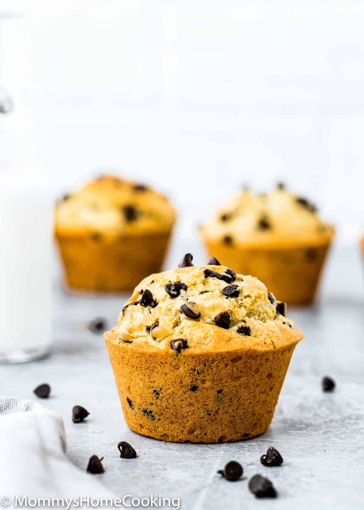 a Eggless Bakery-Style Chocolate Chip Muffin over a gray surface