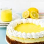 whole eggless lemon cheesecake on a blue surface.