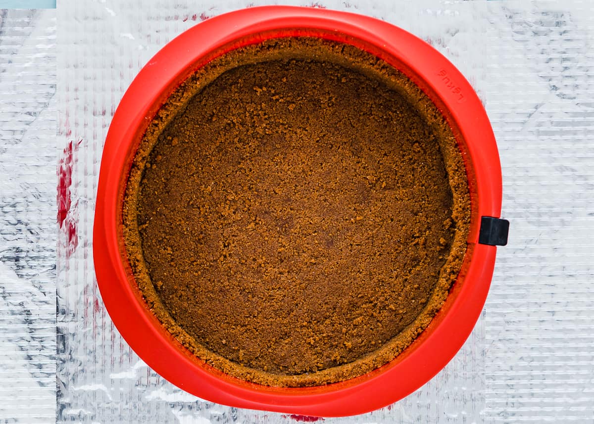 graham cracker crust in a red springform pan.