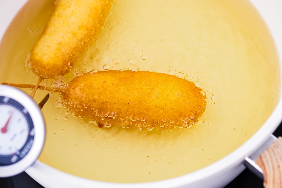 eggless corndogs in a pot with oil.