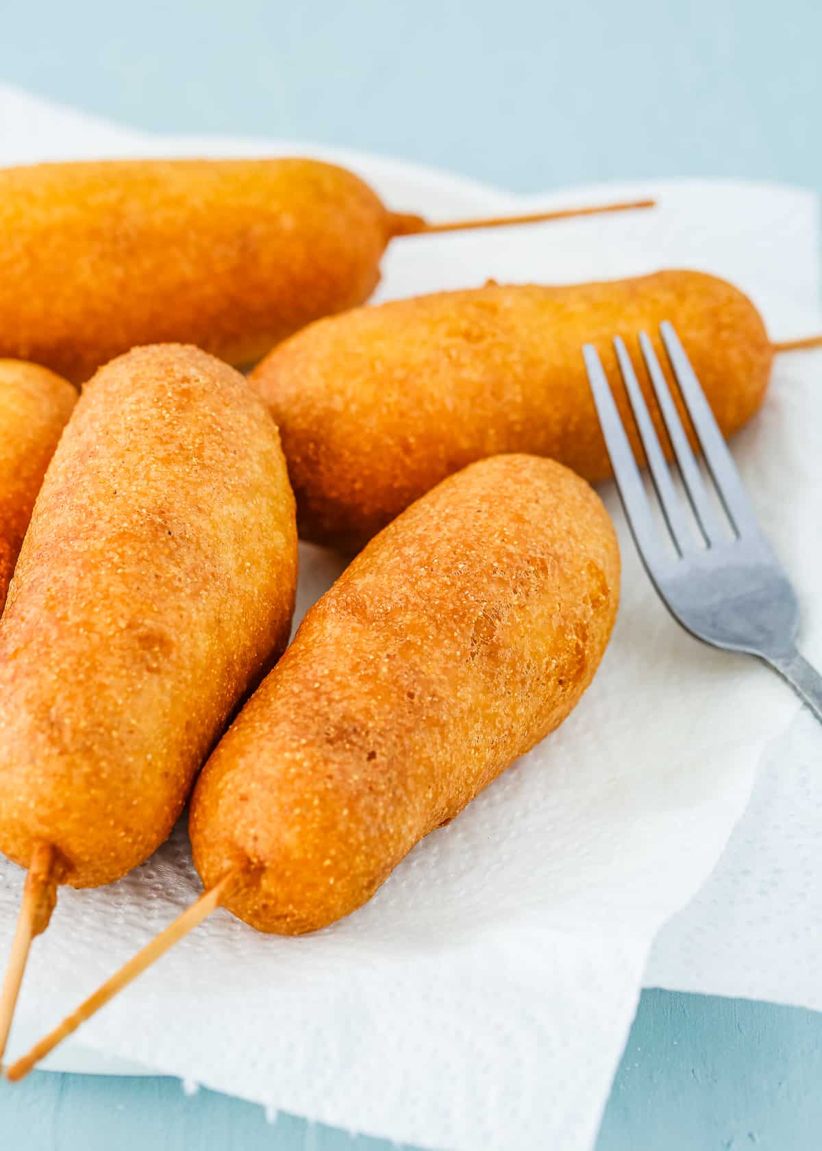 fried eggless corndogs on a plate with papel towel.