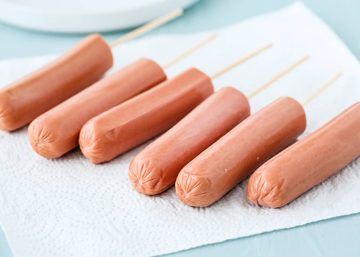 hot dogs with inserted wooden sticks.