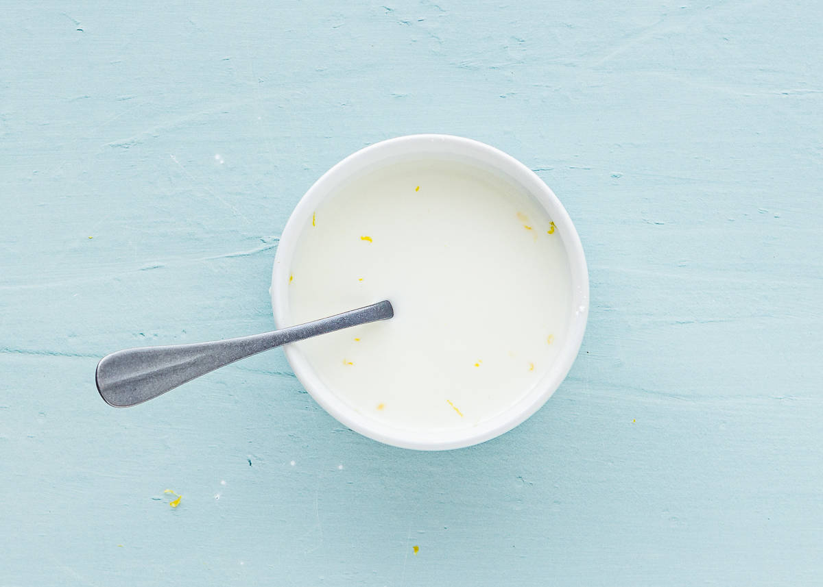 cornstarch and water mixed together in a bowl with a spoon. 