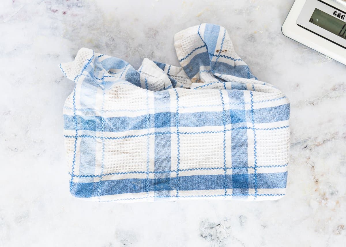 a loaf pan covered with a kitchen towel. 