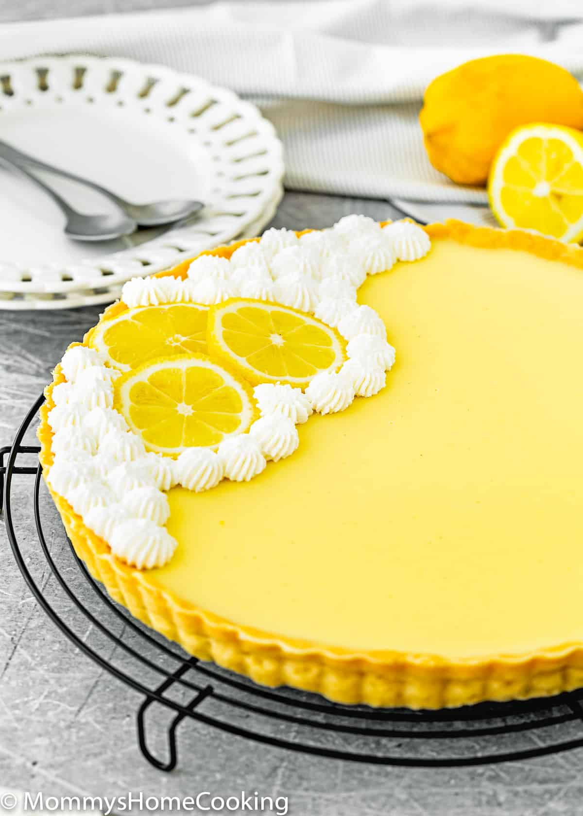 whole Eggless lemon tart decorated with lemon slices and whipped crea,