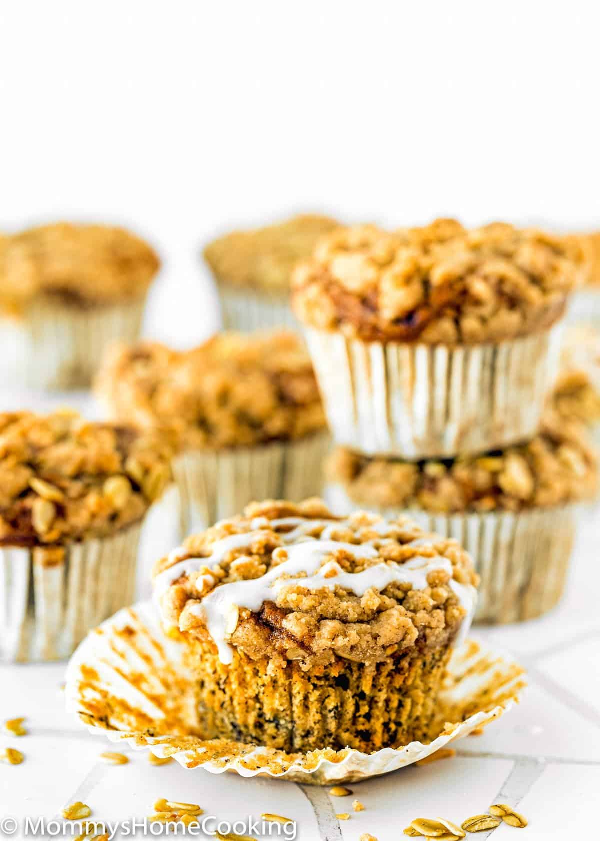 Eggless Banana Crumb Muffins with sugar glaze over a white surface.