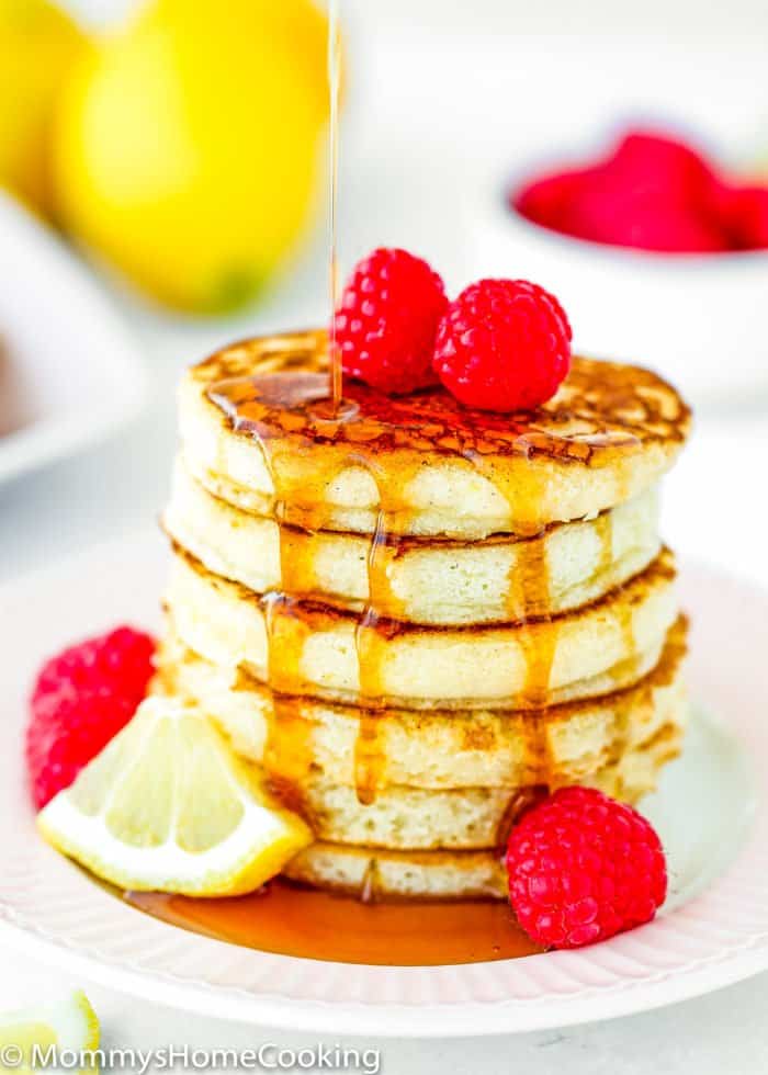maple syrup poured over a stack of eggless lemon Ricotta pancakes