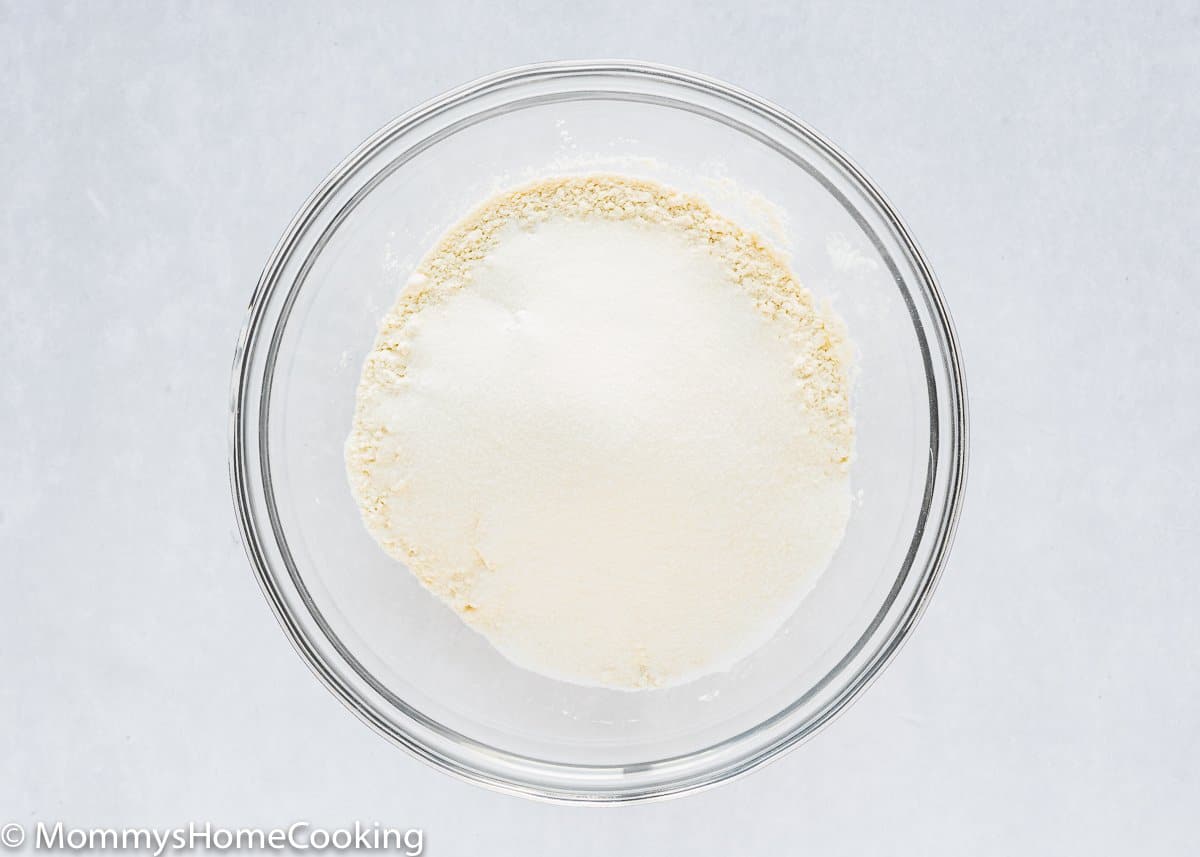 Bahan-bahan kering yang dibutuhkan untuk membuat Eggless Lemon Ricotta Pancakes dalam mangkuk kaca. 