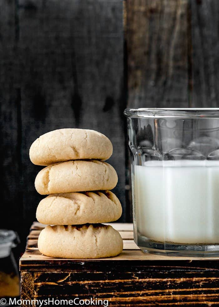 stack of venezuelan polvorosas cookies with a glass of milk