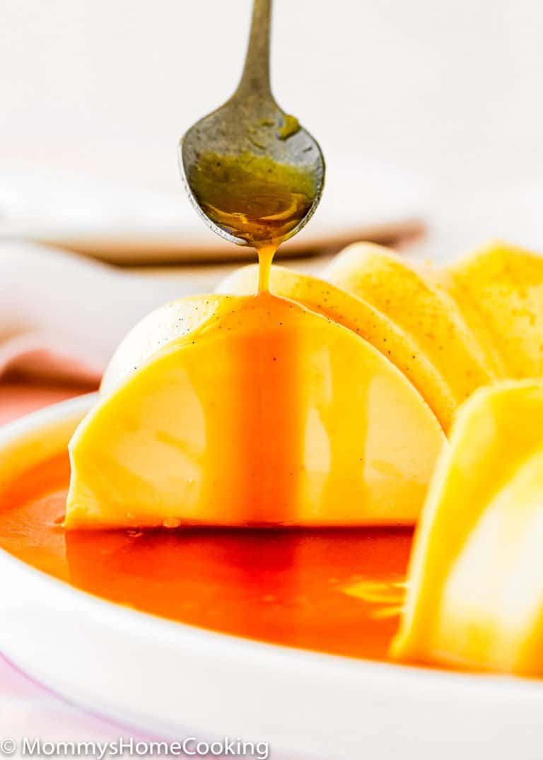 a spoon pouring caramel sauce over a egg-free flan