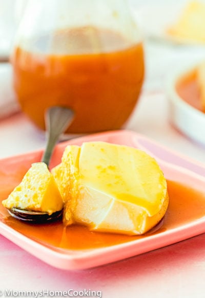 a slice of eggless flan on a plate with a spoon and caramel sauce