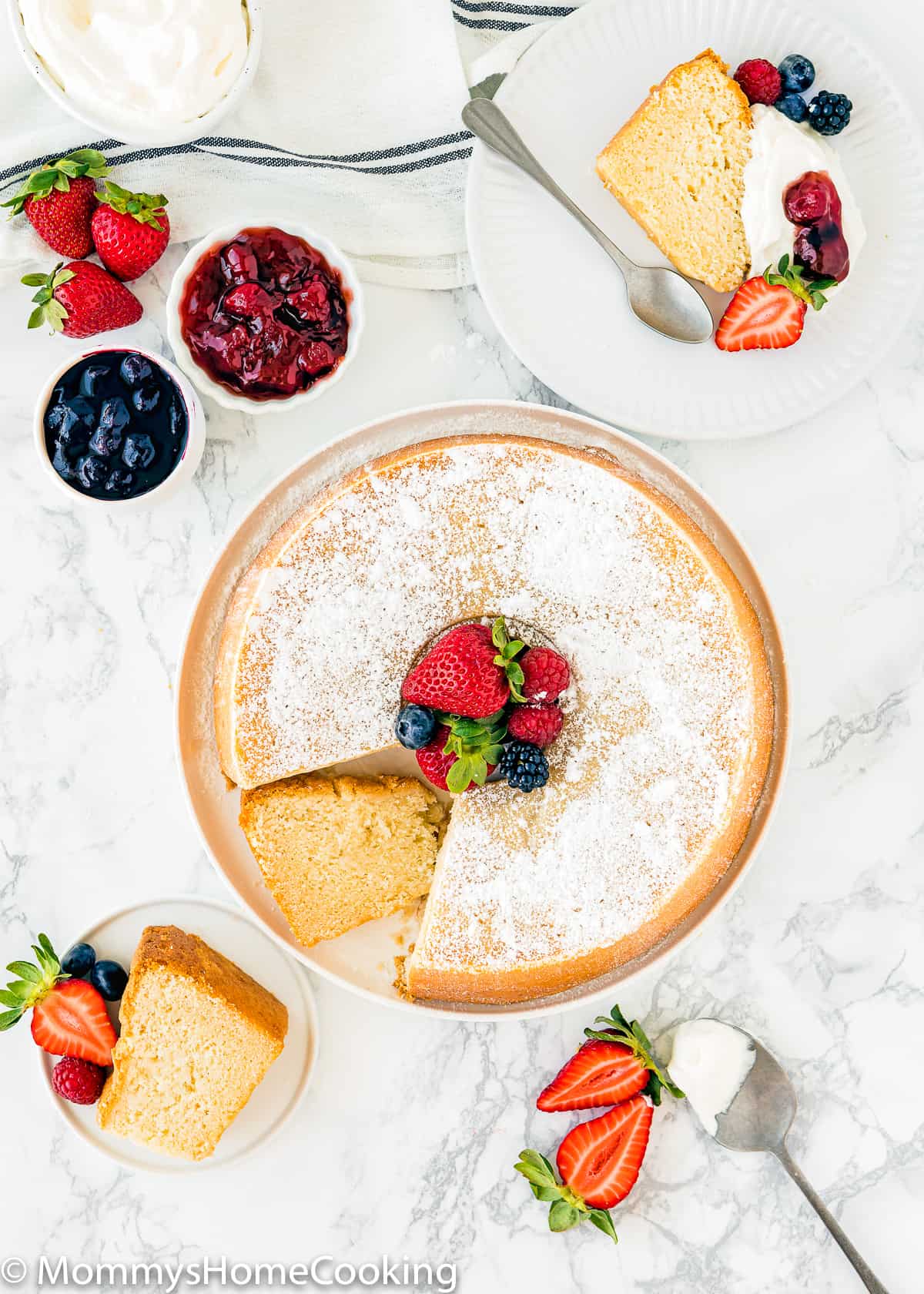 Egg-free Cream Cheese Pound Cake on a serving plate with fresh berries and whipped cream.