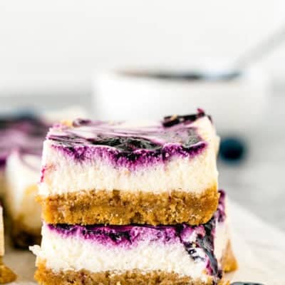 two Eggless Lemon Blueberry Cheesecake Bars stack together