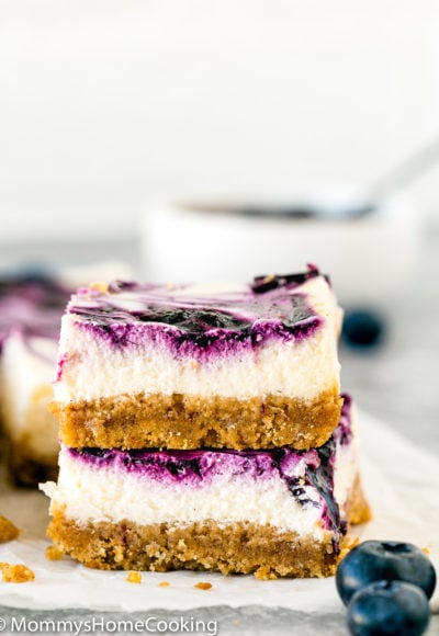 two Eggless Lemon Blueberry Cheesecake Bars stack together
