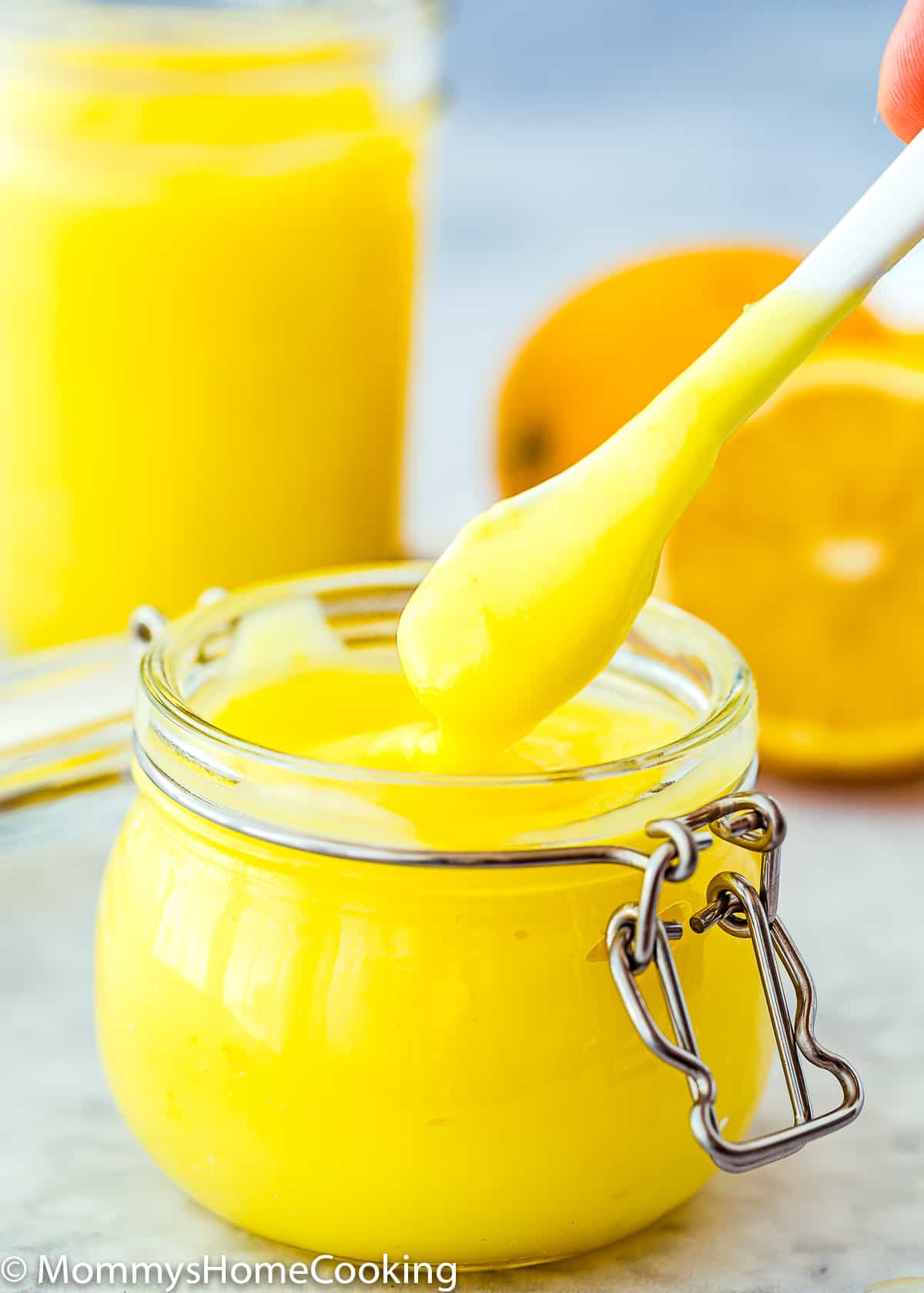 Easy Eggless Lemon Curd in a glass jar with a spoon.