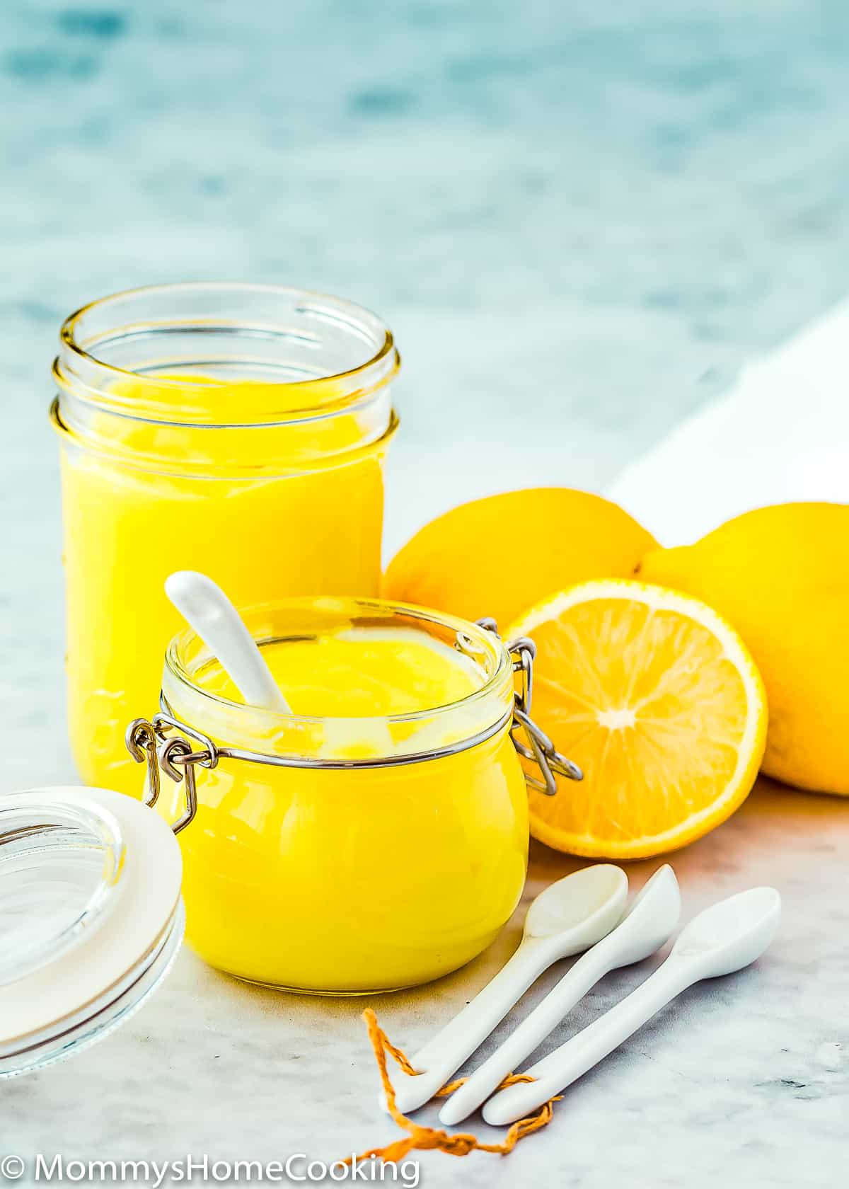 Perfect Eggless Lemon Curd in two glass jars and fresh lemons.