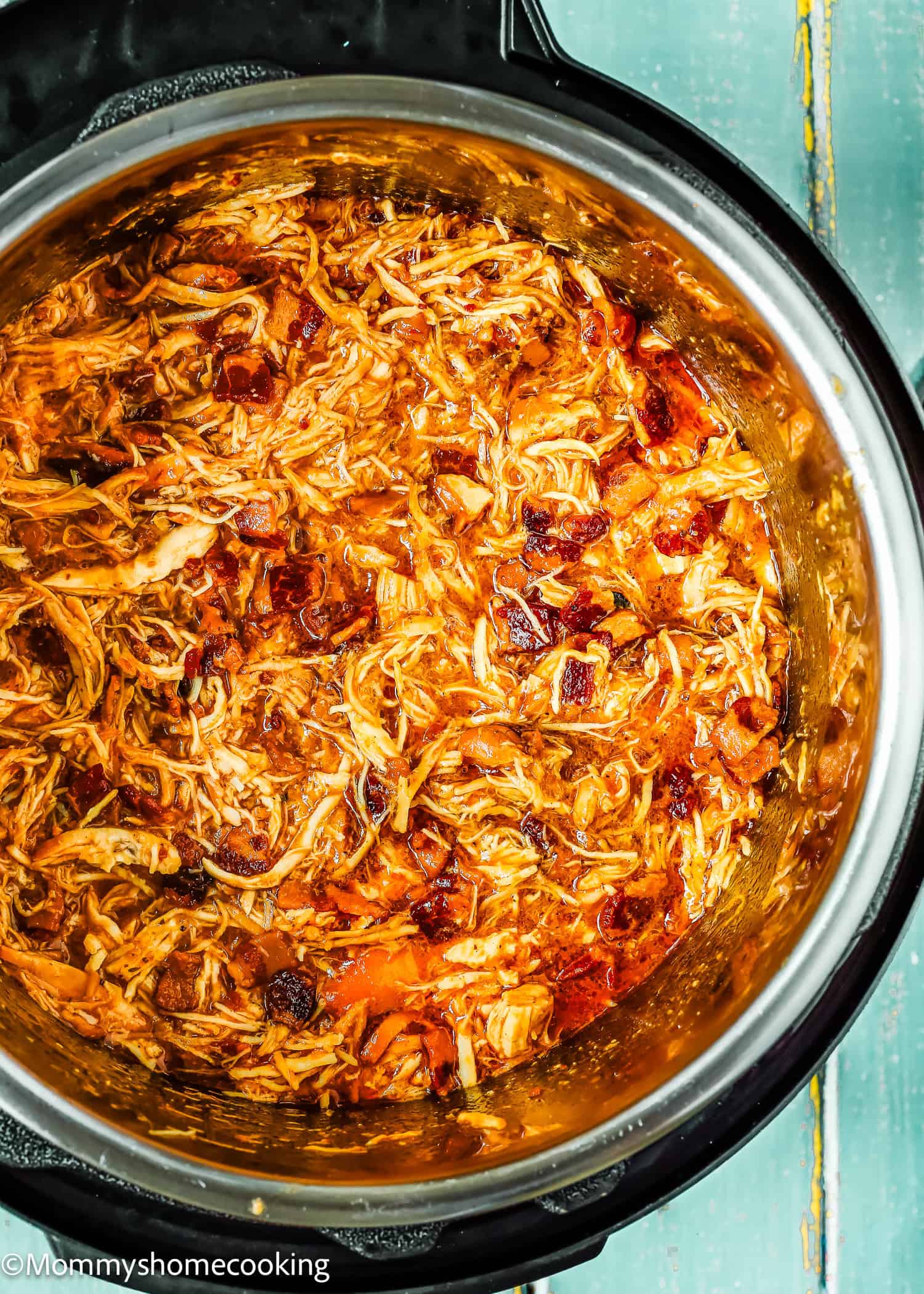 Super easy Bacon Barbecue Chicken shredded in a tomato-based sauce with spices, cooked in an Instant Pot, viewed from above.