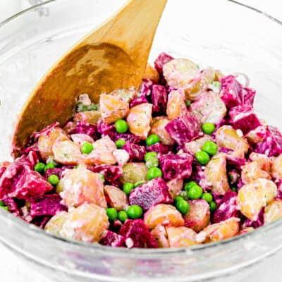 Venezuelan Potato and Beet Salad in a bowl with a wooden spoon.