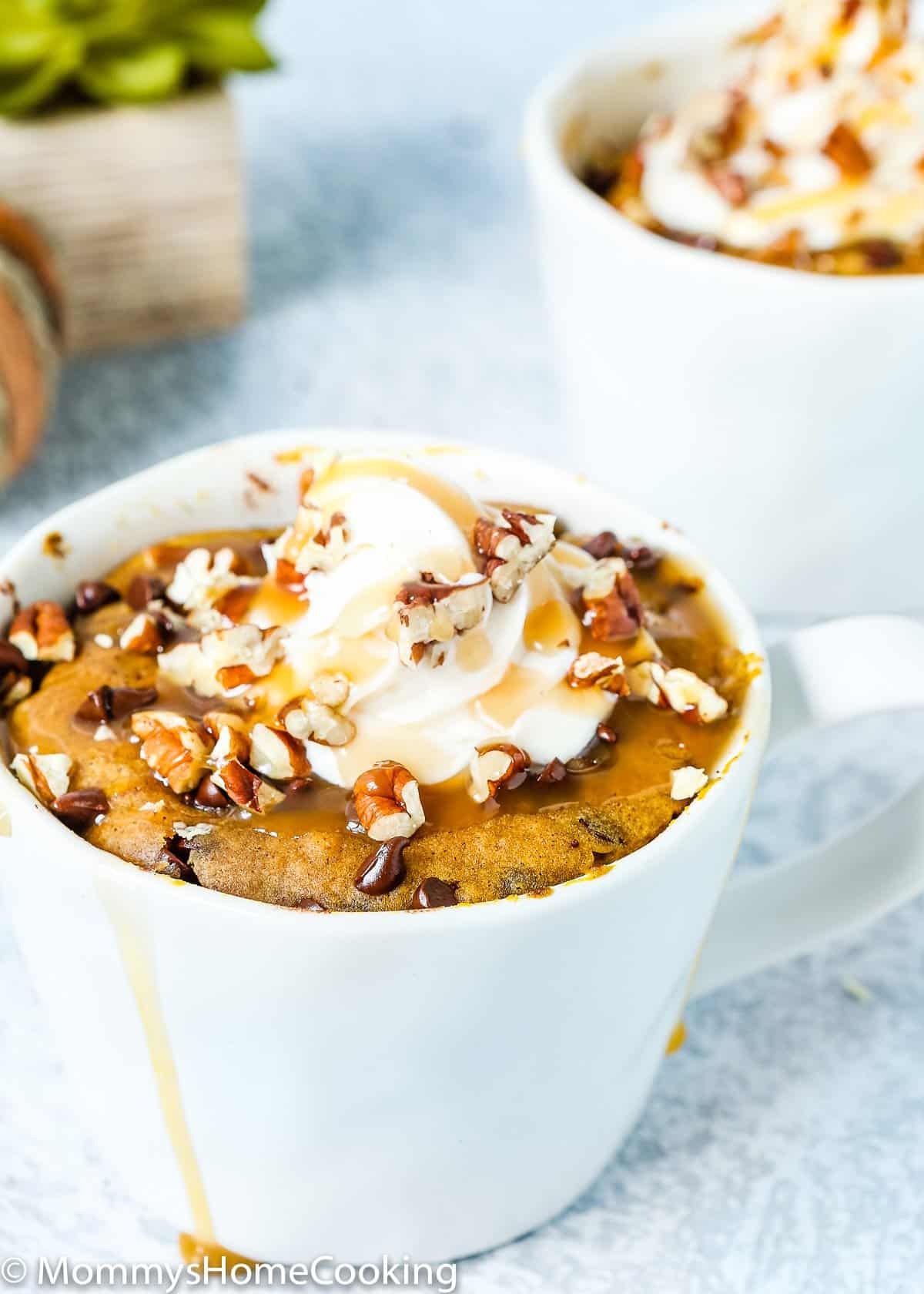 eggless Pumpkin Bread in a Mug with caramel sauce and nuts