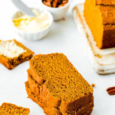 slices of Eggless Pumpkin Bread with butter in the background