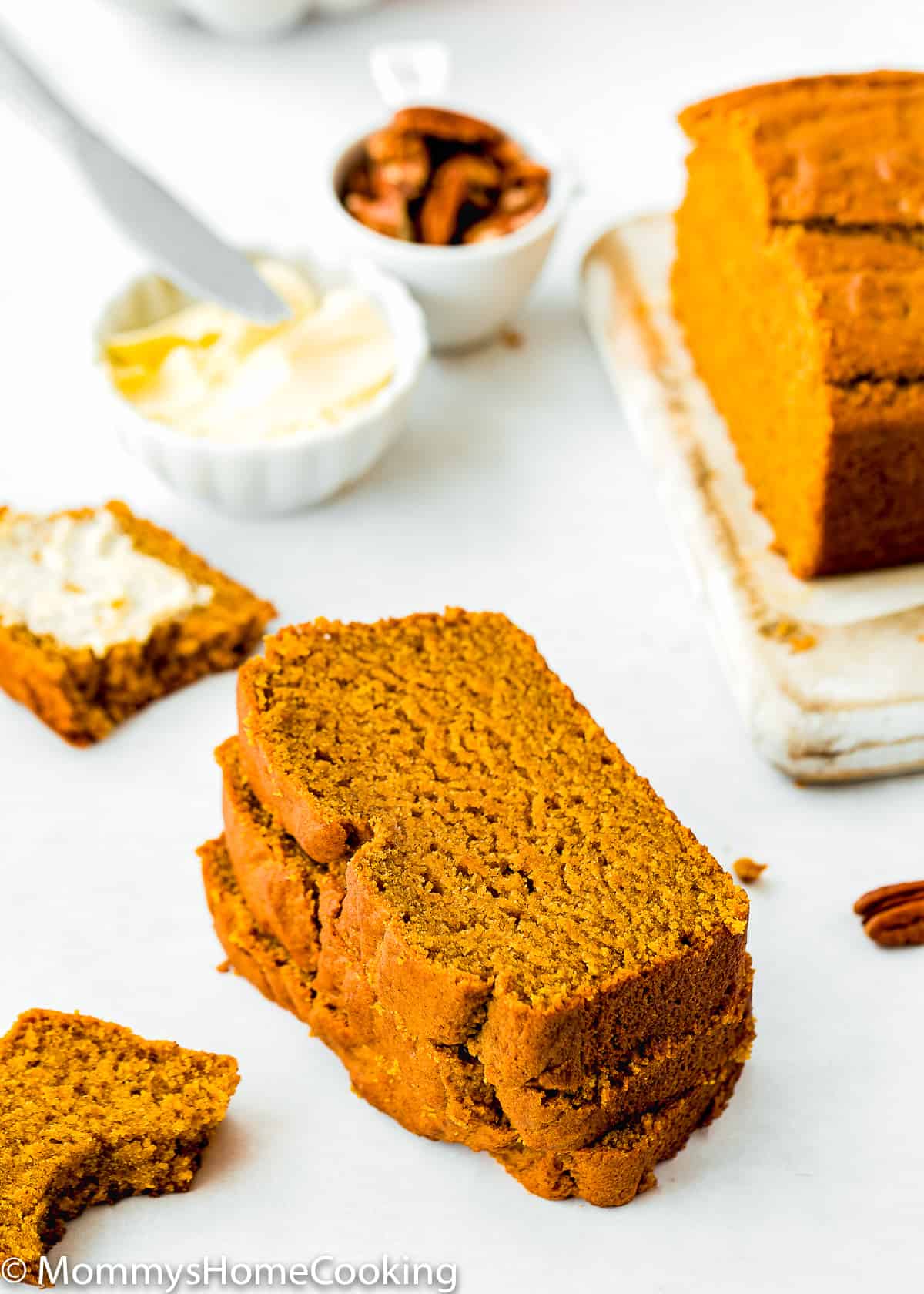 slices of Eggless Pumpkin Bread with butter in the background.
