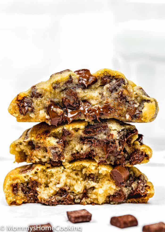 three egg-free chocolate chip cookies cut in half showing its chewy and gooey inside texture.
