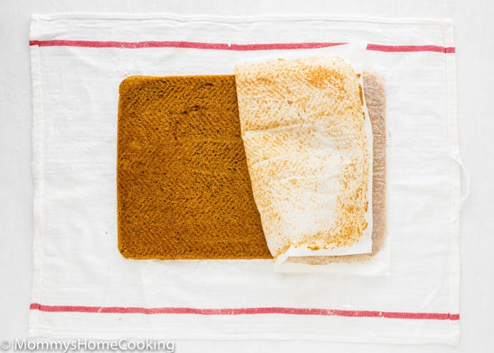 Eggless Pumpkin Roll with parchment paper being removed.