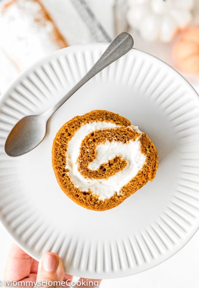 Eggless Pumpkin Roll slice on a white plate with a spoon
