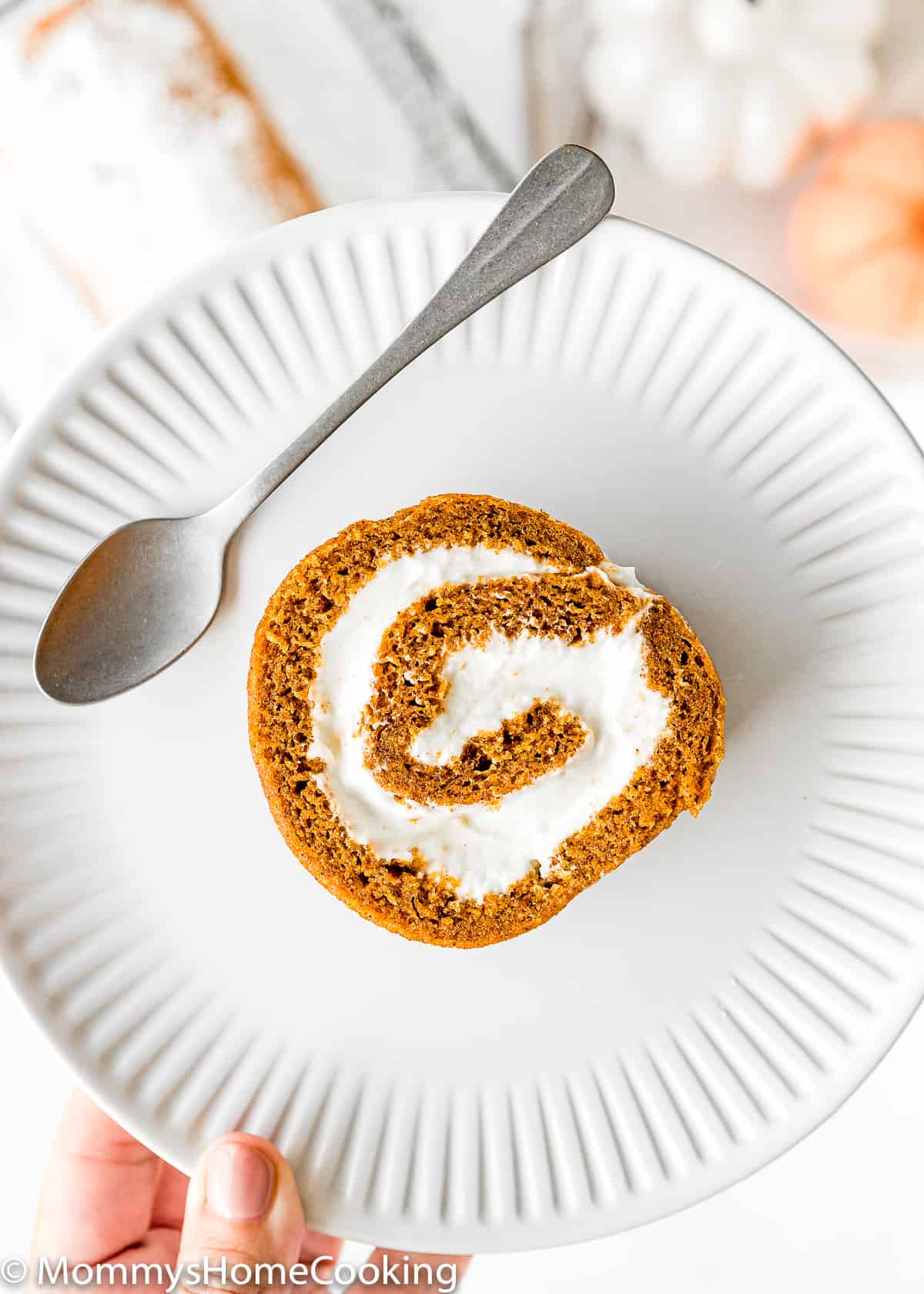 Eggless Pumpkin Roll slice on a white plate with a spoon