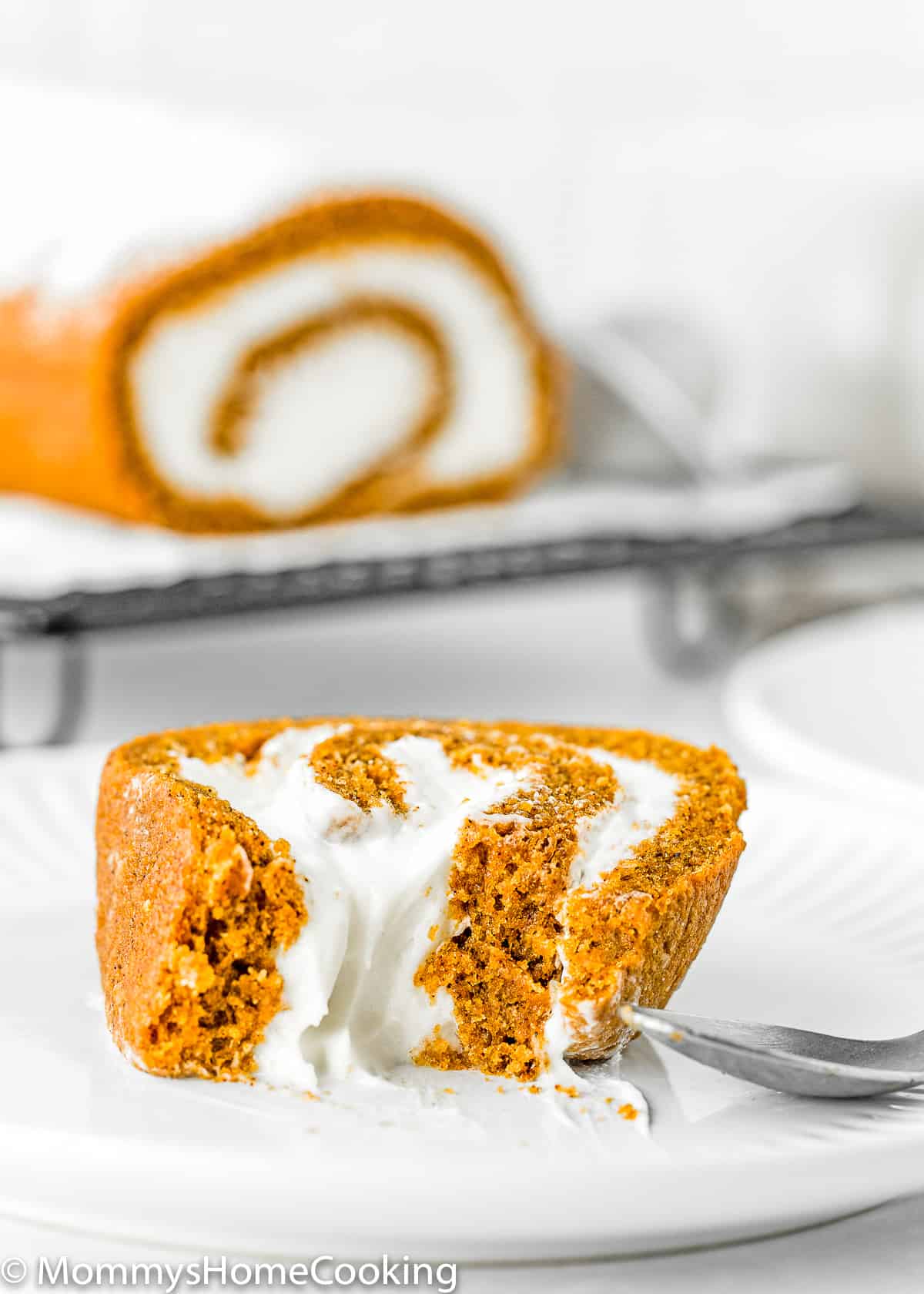 Eggless Pumpkin Roll slice on a plate showing it fluffy inside texture