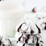 stack of three Eggless Chocolate Crinkle Cookies with a glass of milk