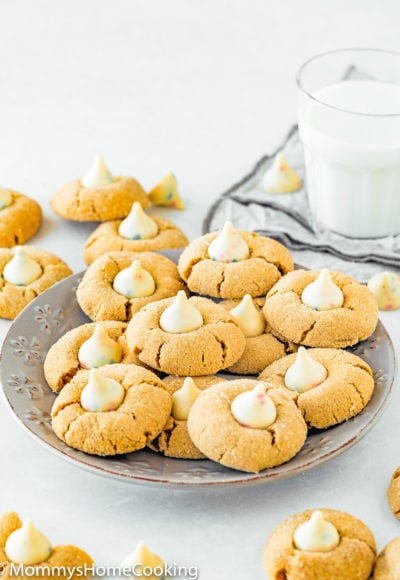 Eggless Peanut Butter Blossom Cookies on a plate with a glass of milk in the background