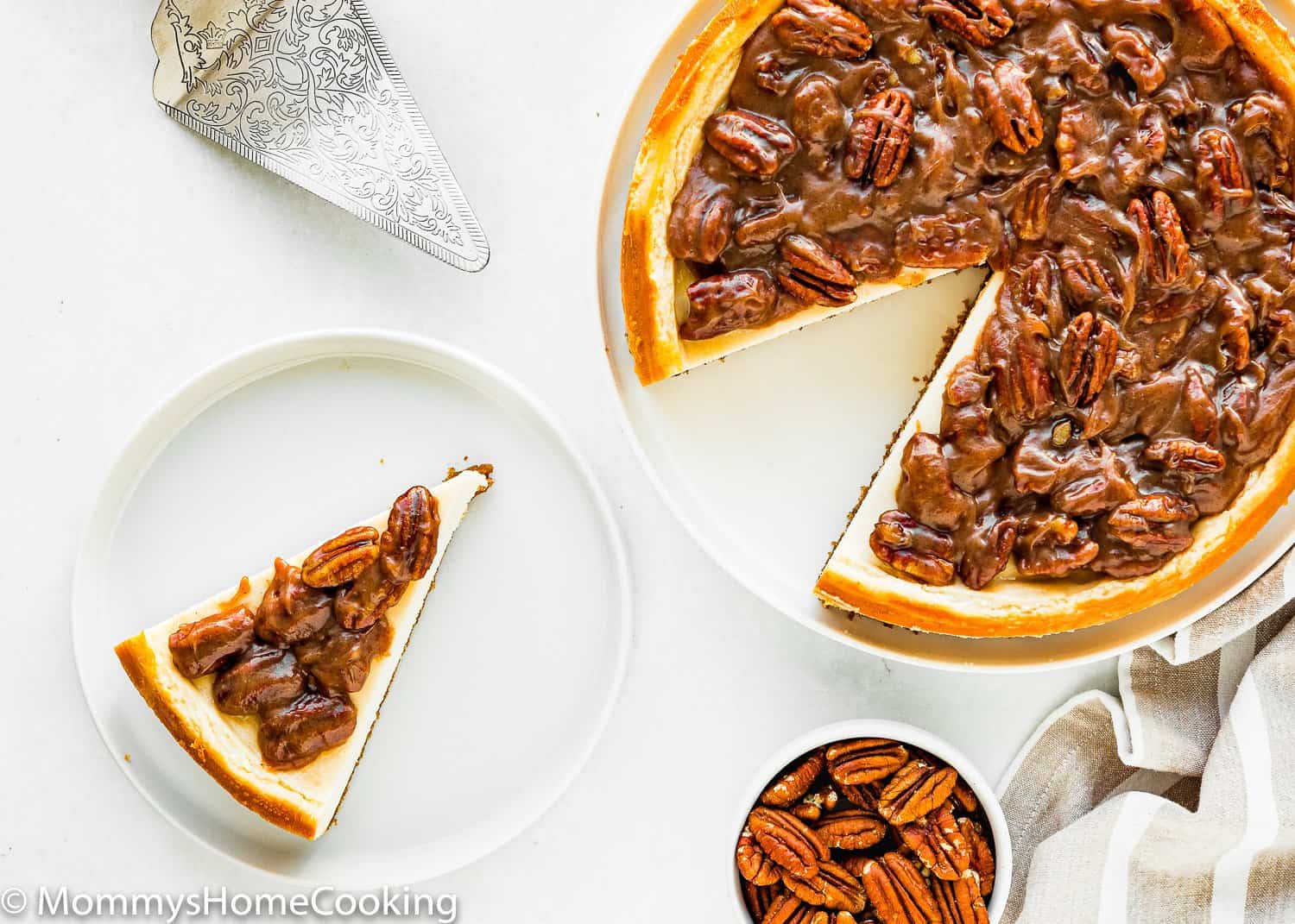 slice of cheesecake on a plate with pecan in a bowl on the side