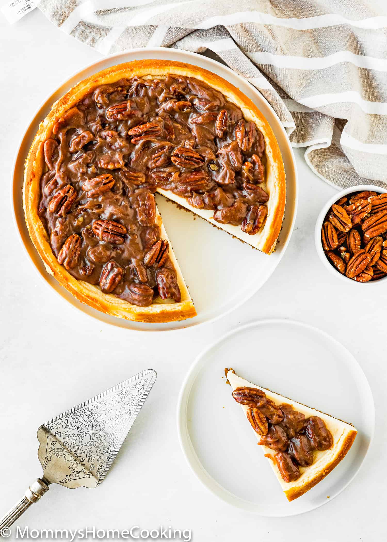 overhead view of an Eggless Pecan Pie Cheesecake sliced with a cake server.