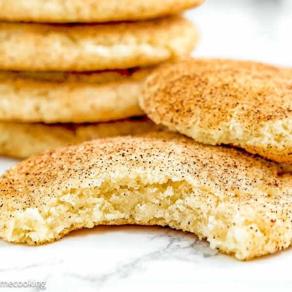 bitten Eggless Snickerdoodle Cookies over a marble surface.