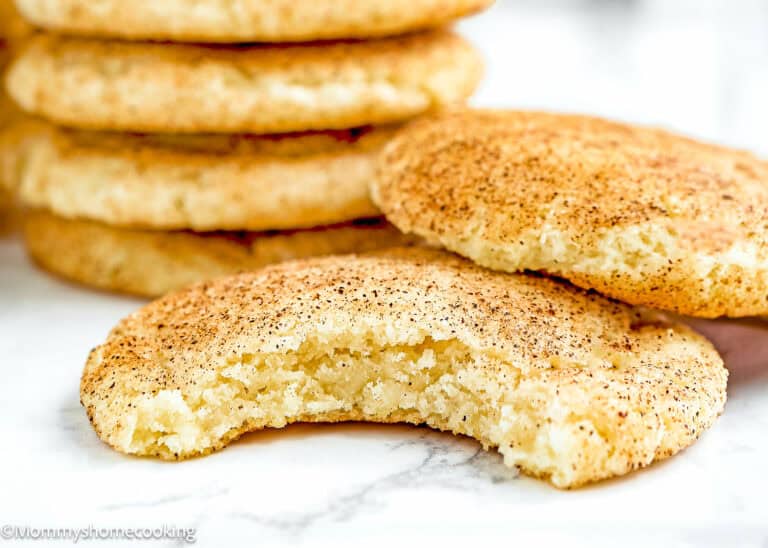 bitten Eggless Snickerdoodle Cookies over a marble surface.