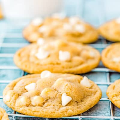 Close-up of eggless white chocolate cookies shaped like hearts on a cooling rack.