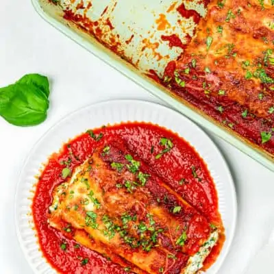 a plate with Eggless Cheese Manicotti and a baking dish on the side